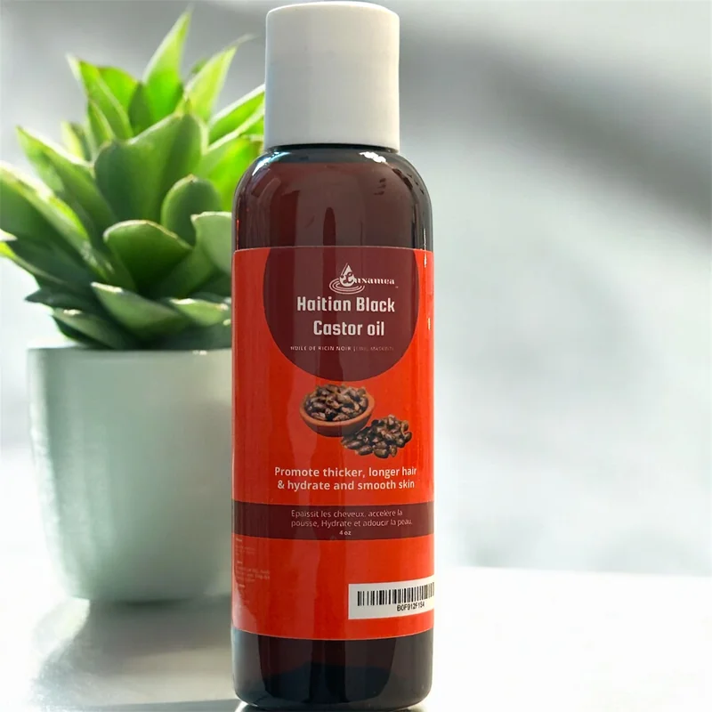LUXAMEA Haitian Black Castor Oil bottle beside a green plant